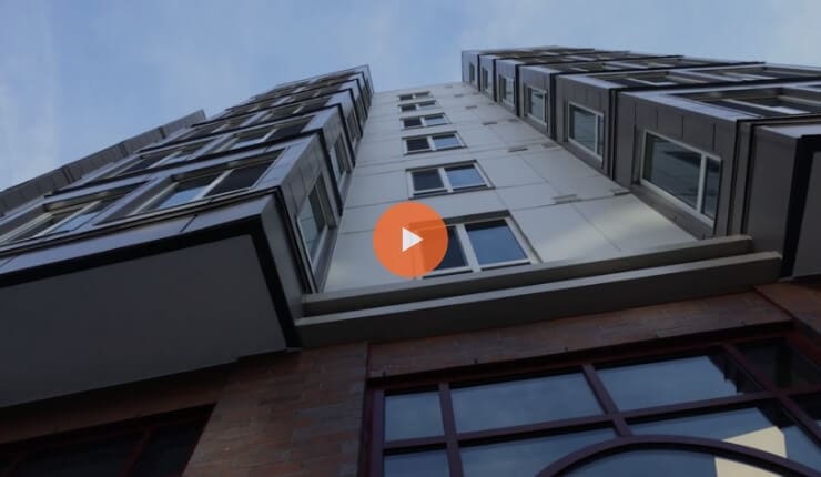 True-Ground-Partner-with-Real-Estate-Riggs-Crossing-Senior-Residences-Video@2x Screenshot of a video where you can see a building from below.
