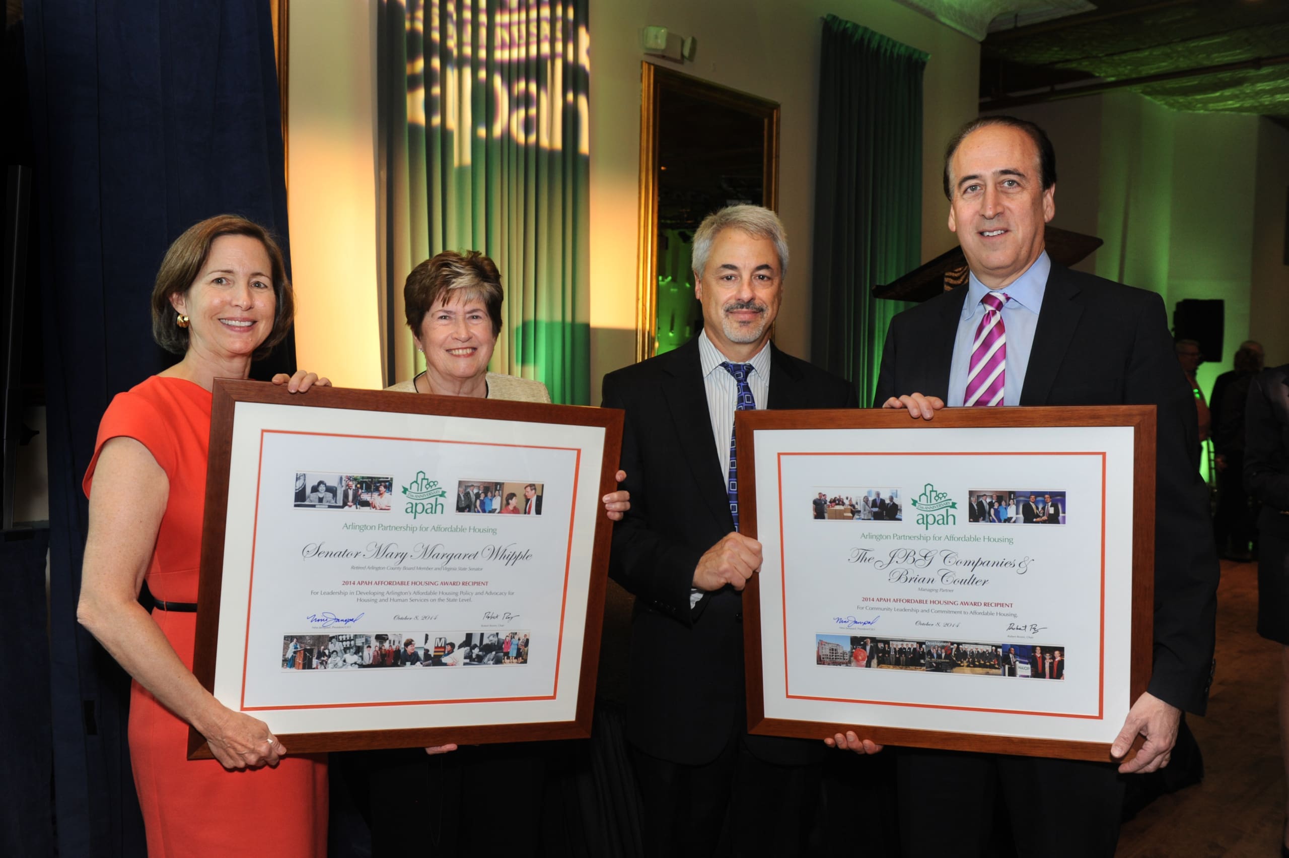 Group of four award recipients holding framed certificates at an APAH event