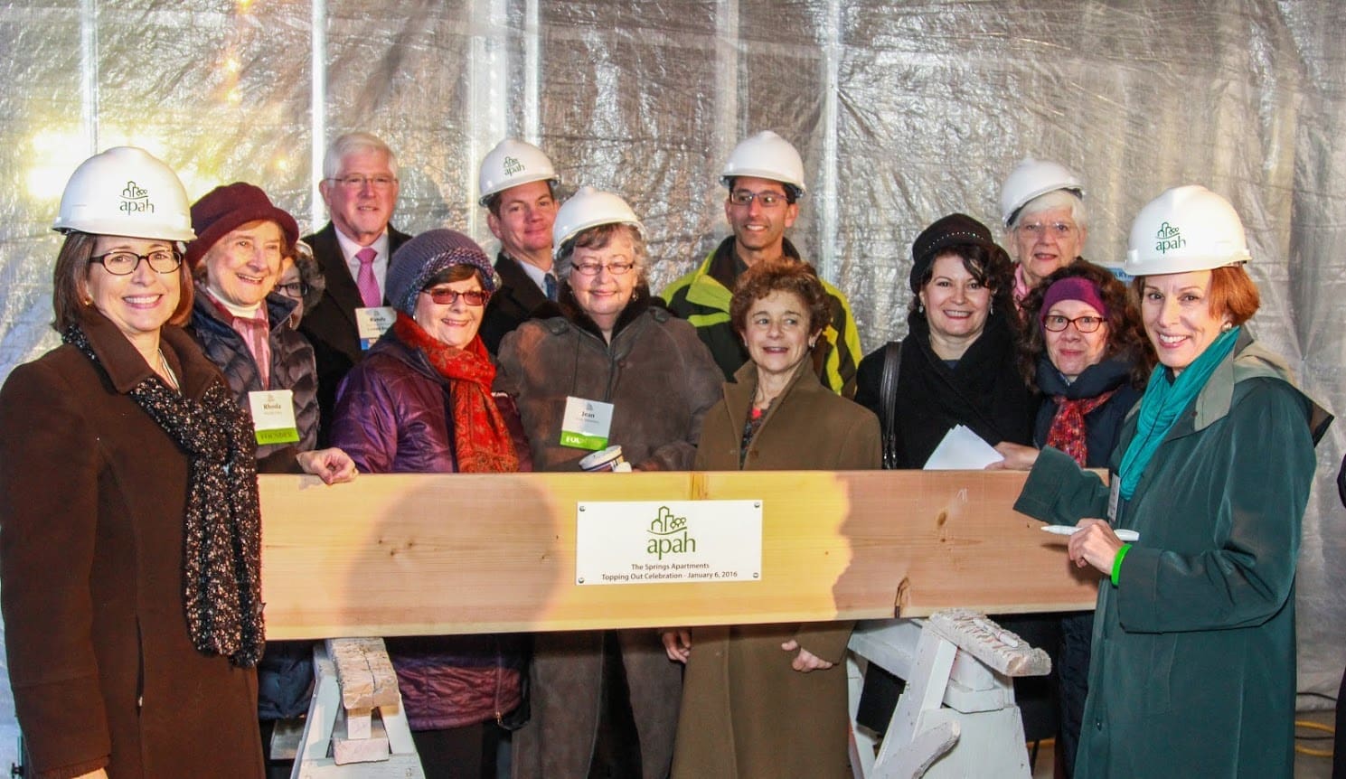 Group of people in hard hats celebrating the topping-out of The Springs Apartments.