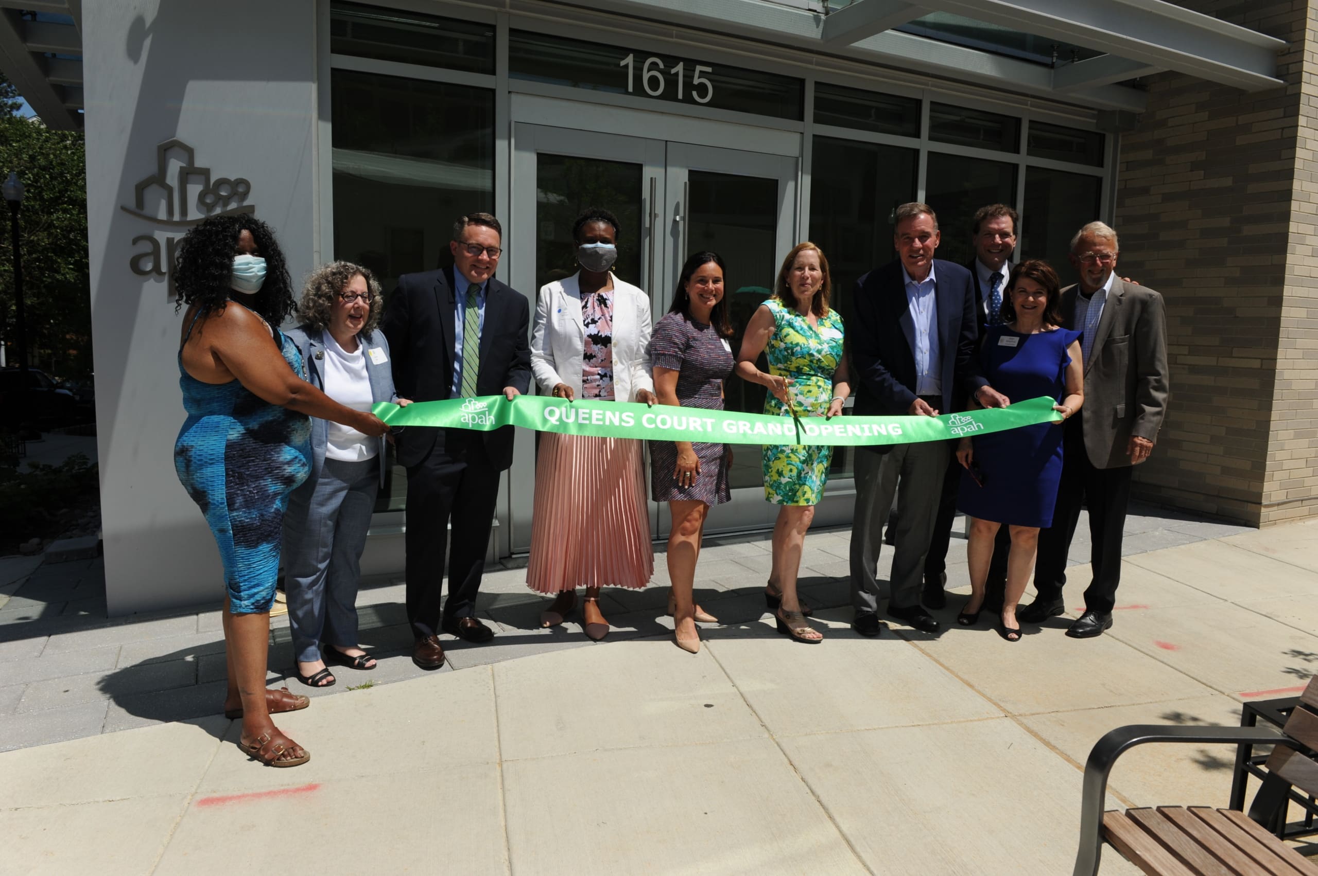 APAH leaders join local, state and federal government representatives to cut the grand opening ribbon at Queens Court in June, 2021
