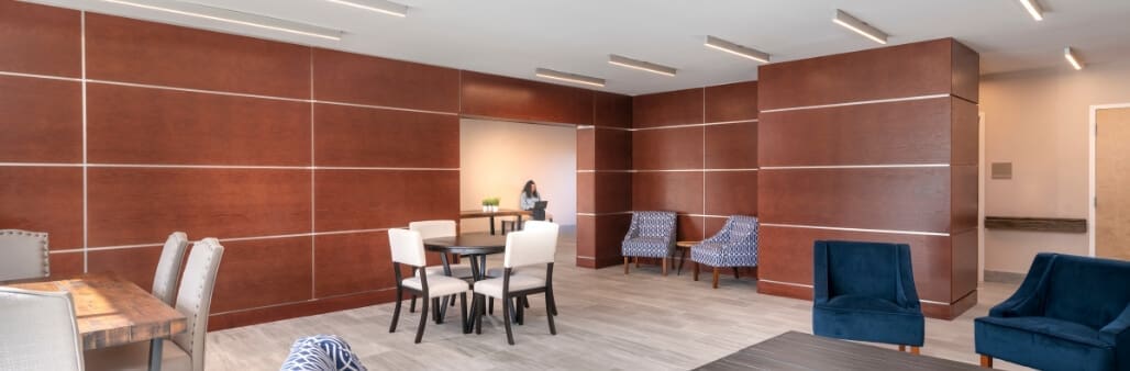 Modern lounge area with blue and white furniture and wooden panel walls