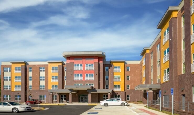 Exterior view of a modern multi-story residential building with colorful accents.